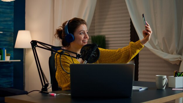 Entertainment blogger doing selfie during broadcast working from home studio. On-air online production internet podcast show host streaming live content, recording digital social media communication