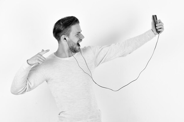 Entertainment and music concept Guy with beard holds phone