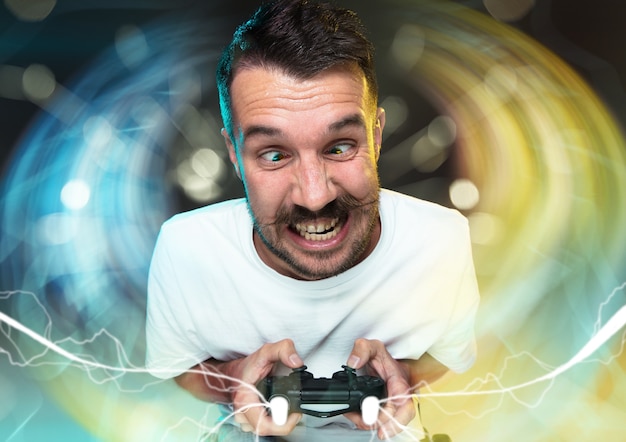 Foto enthousiaste gamer vrolijke jongeman met een videogamecontroller vol emoties