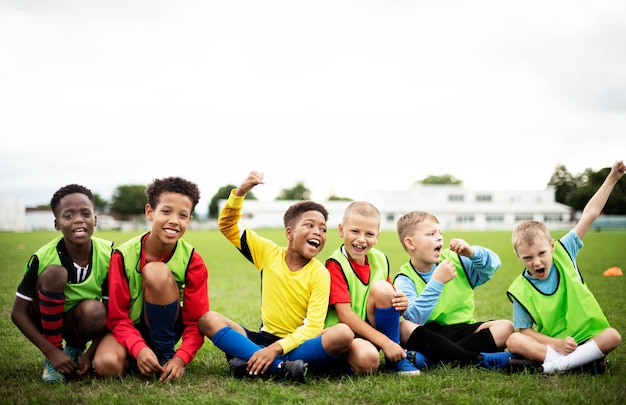 Photo enthusiastic football players sitting on the field