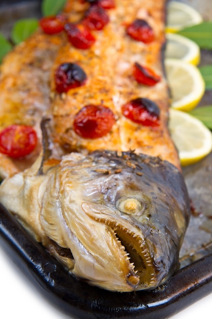Entire salmon cooked with tomatoes ,lemon and laurel