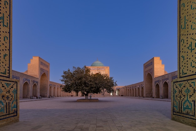 夜明けブハラ ウズベキスタンの古代カリヤン モスクの中庭への入り口