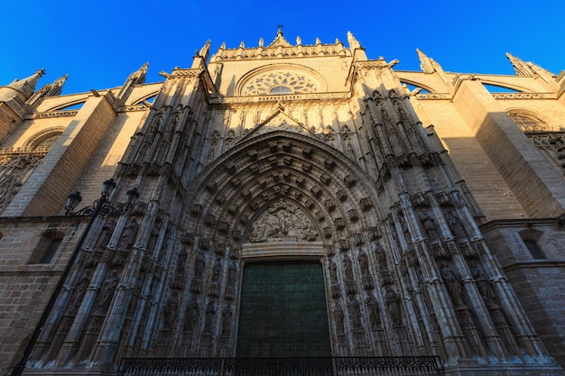 Entrance door of Seville Cathedral (or Cathedral of Saint Mary of the See), exterior, in evening. Build in 1402-1506.