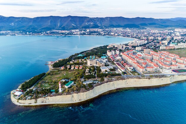 Entrance from a height to the Gelendzhik Bay at sunset in calm, windless weather. In the foreground is a "Thick" Cape with a lighthouse,