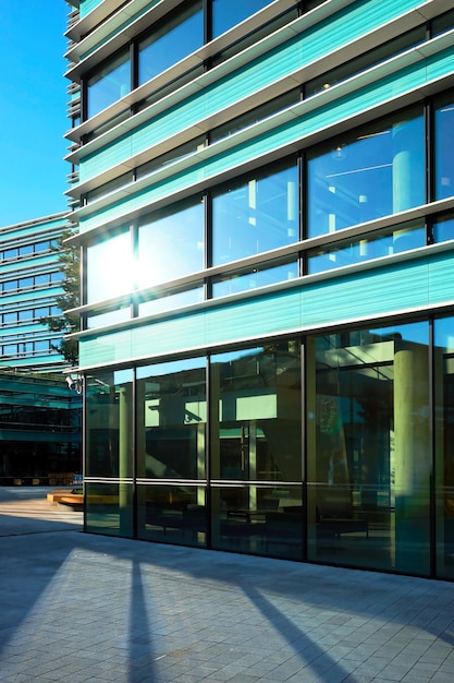 青い空を映す現代の鉄鋼とガラスの超高層ビルの商業建築への入り口