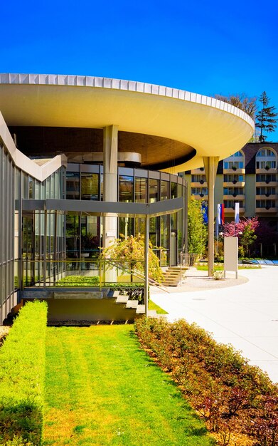 Entrance into Medical center building in Old city in Rogaska Slatina in Slovenia in Styria. Travel in Europe Slovenian spa resort. Modern glass architecture exterior with flags