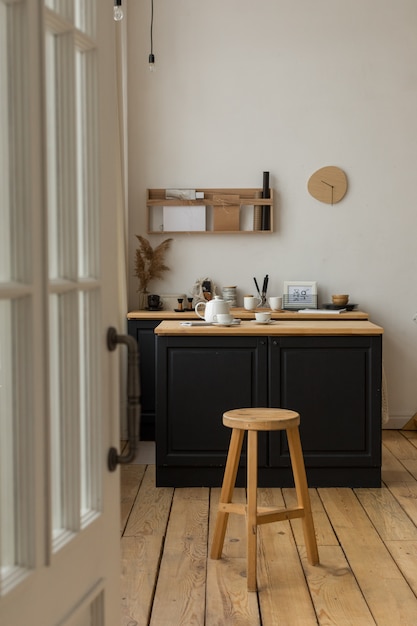 Entrance to light kitchen with served table and stool