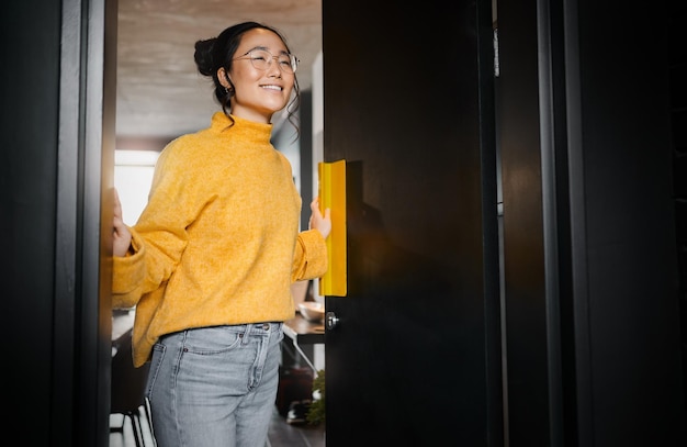 Foto entree creatieve en aziatische vrouw die een deur opent naar een kantoor bij een startend bedrijf voor grafisch ontwerp visie blij en japanse ontwerper op een werkruimte met een idee, motivatie en inspiratie