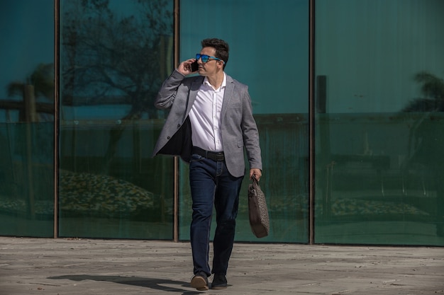 Предприниматель отвечает на телефонный звонок во время прогулки по улице
