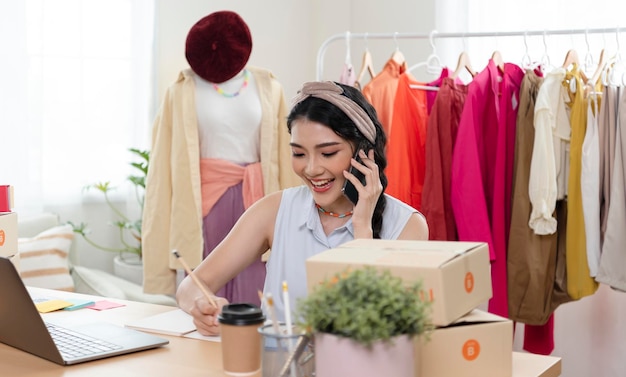 기업가 아시아 젊은 여성 집에서 일하는 옷 체크 주문 제품 판매