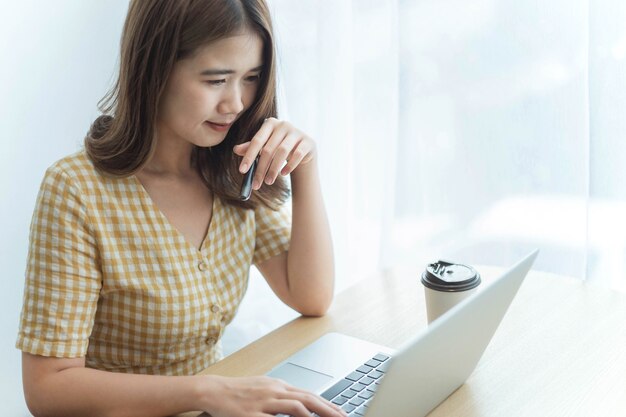 기업가 개념은 젊은 여성 사업가가 고객에게 이메일에 답장하기 위해 노트북에 입력합니다.