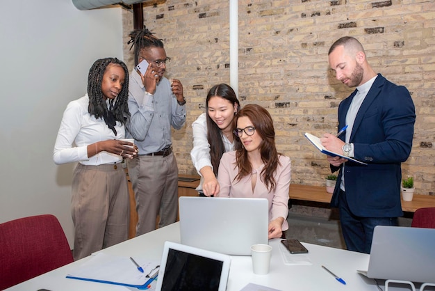 entrepreneur sitting in the boardroom with multiethnic coworkers  discussing new strategies