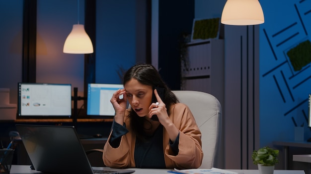 Entrepreneur stressed woman analysing marketing strategy on laptop talking with company manager