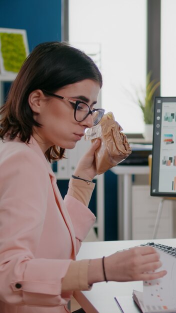 Entrepreneur woman having delivery meal food order at desk\
takeaway lunchtime