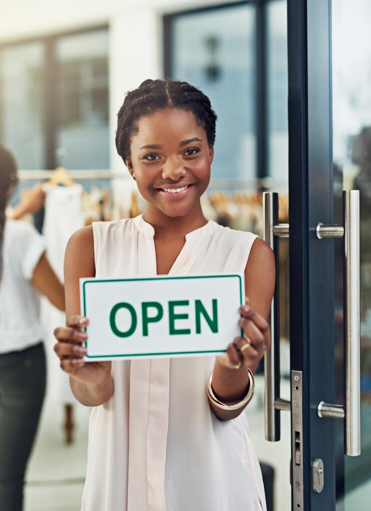 Photo entrepreneur woman and portrait with open sign in shop for welcome ready for service and small business owner poster board and start day at boutique door in startup store for fashion and clothing