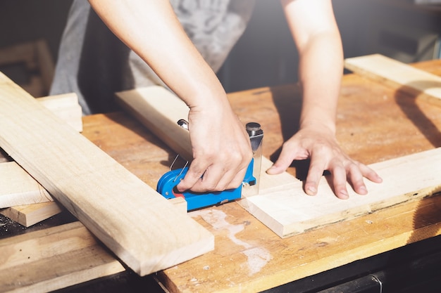 Entrepreneur  Woodwork holding a Tacker to assemble the wood pieces as the customer ordered.