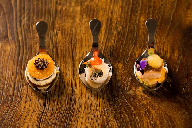 Entry, entree and dessert of finger food in a spoon