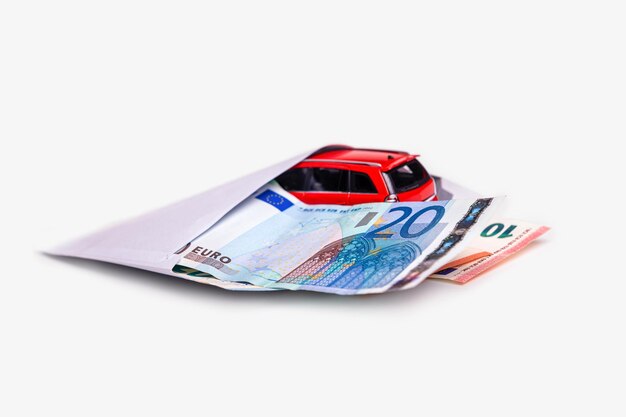 Envelop met eurobankbiljetten en auto geïsoleerd op wit transportkosten planning concept
