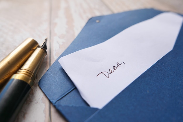 Envelope , empty paper and fountain pen on table