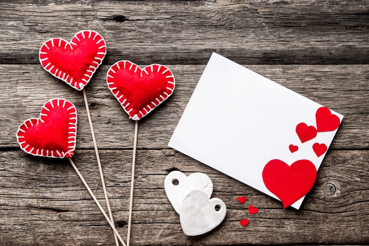 Photo envelope and red hearts on a wooden background