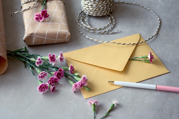 Envelope and self made greeting card concept with fresh carnation flowers