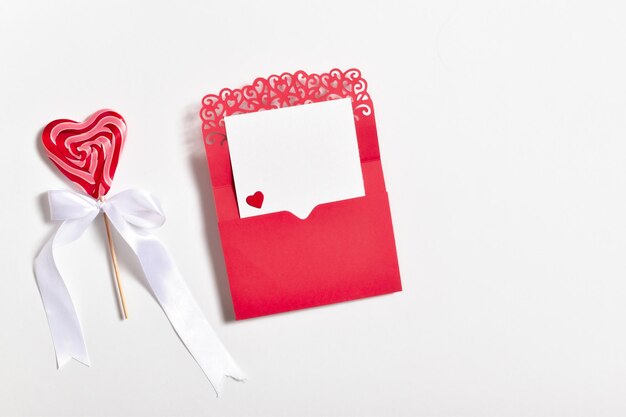 Photo an envelope with a blank sheet of heartshaped lollipop copy space flat lay top view