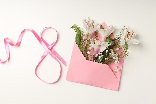 Envelope with flowers and 8 made of ribbon on white background