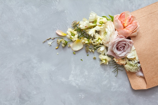 envelope with flowers on the stone gray background. flat lay