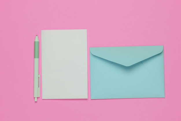 Envelope with a letter and pen on pink background Valentines day wedding or birthday Top view