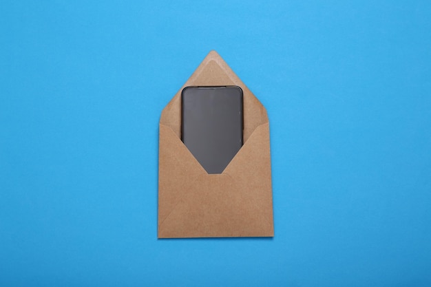 Envelope with smartphone on blue background