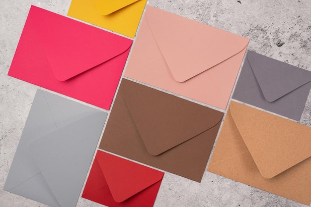 Photo envelopes of a different size and color on a light concrete background