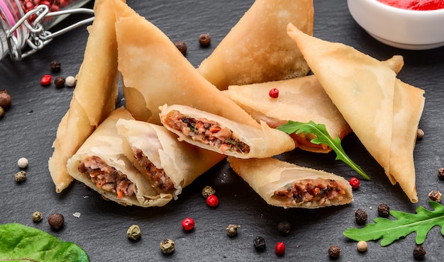 Envelopes of dough with toppings and spicy sauce. Asian cuisine