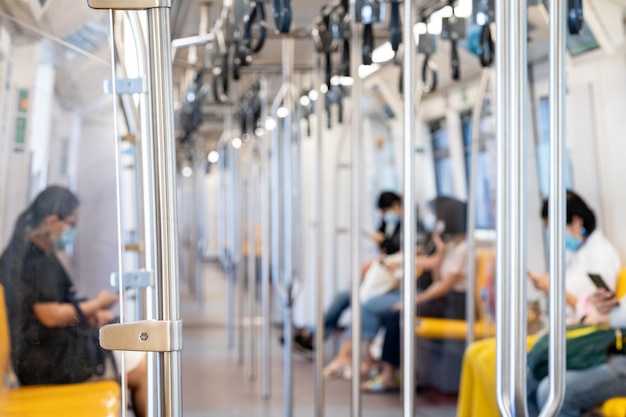 The environment of asia passengers inside the sky train with the masks on all people's faces