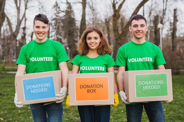 Photo environment and volunteer concept with persons holding boxes for donations