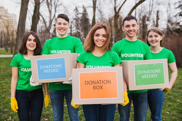 Ambiente e concetto di volontariato con persone che tengono le scatole per le donazioni