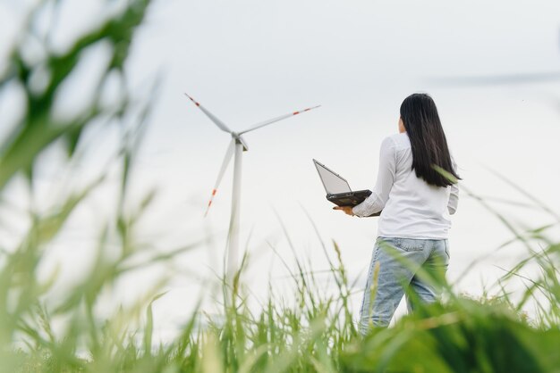 写真 風力発電所でラップトップを持っている環境エンジニア