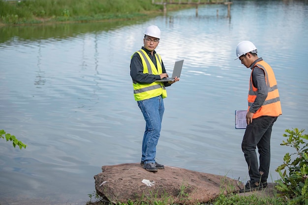 Foto ingegneri ambientali ispezionano la qualità dell'acqua portare l'acqua in laboratorio per i testcontrollare il contenuto di minerali nell'acqua e nel suolo consultazione per risolvere il problema delle fonti d'acqua contaminate da sostanze chimiche