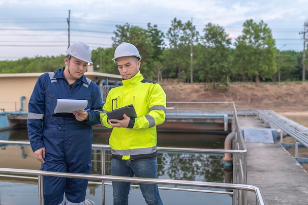 Foto gli ingegneri ambientali lavorano presso gli impianti di trattamento delle acque reflue l'ingegneria dell'approvvigionamento idrico lavora presso l'impianto di riciclaggio dell'acqua per il riutilizzo. tecnici e ingegneri discutono del lavoro insieme