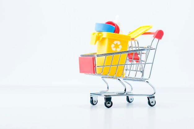 Environmental, pollution plastic trash concept. Modern trash bin with garbage in shopping trolley.