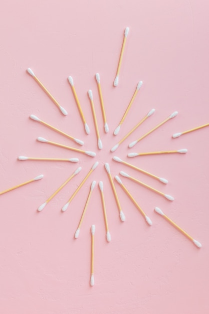 Environmentally friendly bamboo and cotton cotton buds on a pink background bamboo toothbrushes for