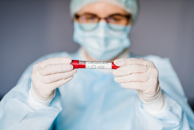 Epidemic Corona virus. Doctor holding blood test, positive result, rapidly spreading Coronavirus, China. Tube with sample blood for 2019-nCoV.