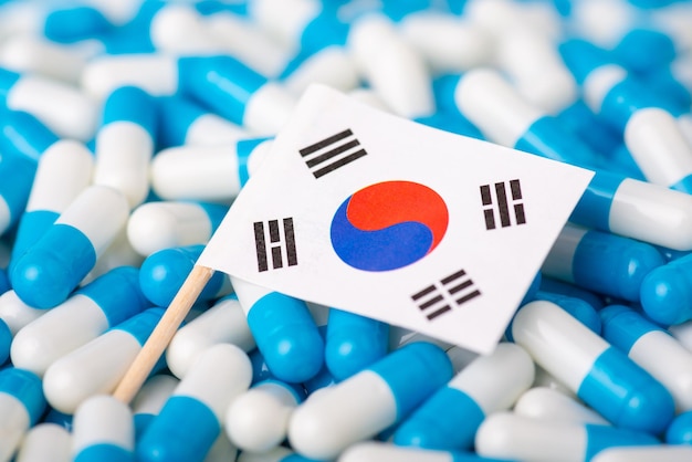 Epidemie in Korea. Vlag van Zuid-Korea op stapels pillen