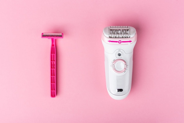 Epilator and razor on pink background.