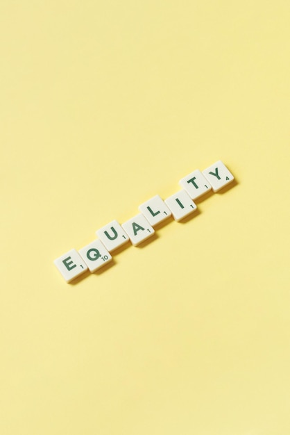 Equality formed of scrabble blocks on yellow background