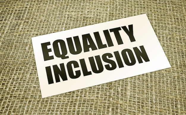 Equality Inclusion words on card on burlap canvas Business concept