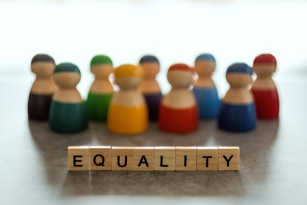 Photo equality word on wooden blocks with diverse people in the background