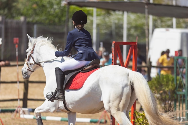 馬術スポーツ、牧場で馬に乗って制服を着た 10 代の少女