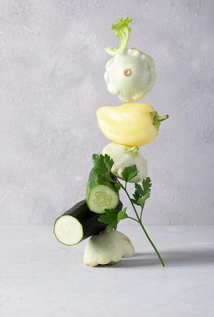 Equilibrium floating fresh vegetables on gray table