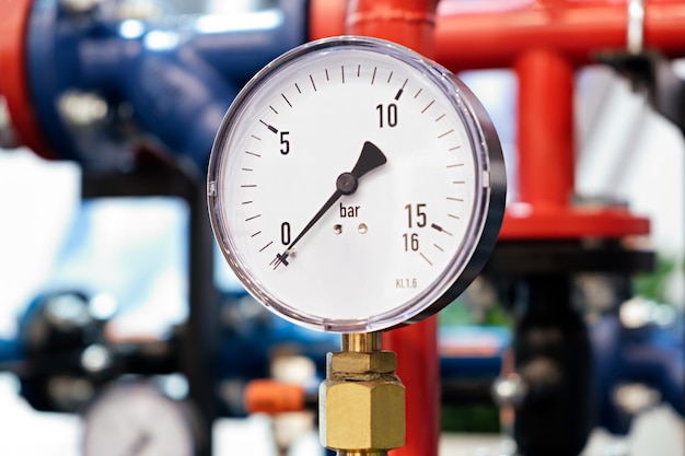 The equipment of the boilerhouse valves tubes pressure gauges thermometer Close up of manometer pipe flow meter water pumps and valves of heating system in a boiler room