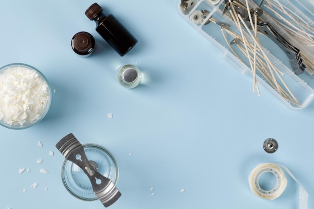 Equipment for candle making with white soy wax flakes fragrance and jar wicks Flatlay top view